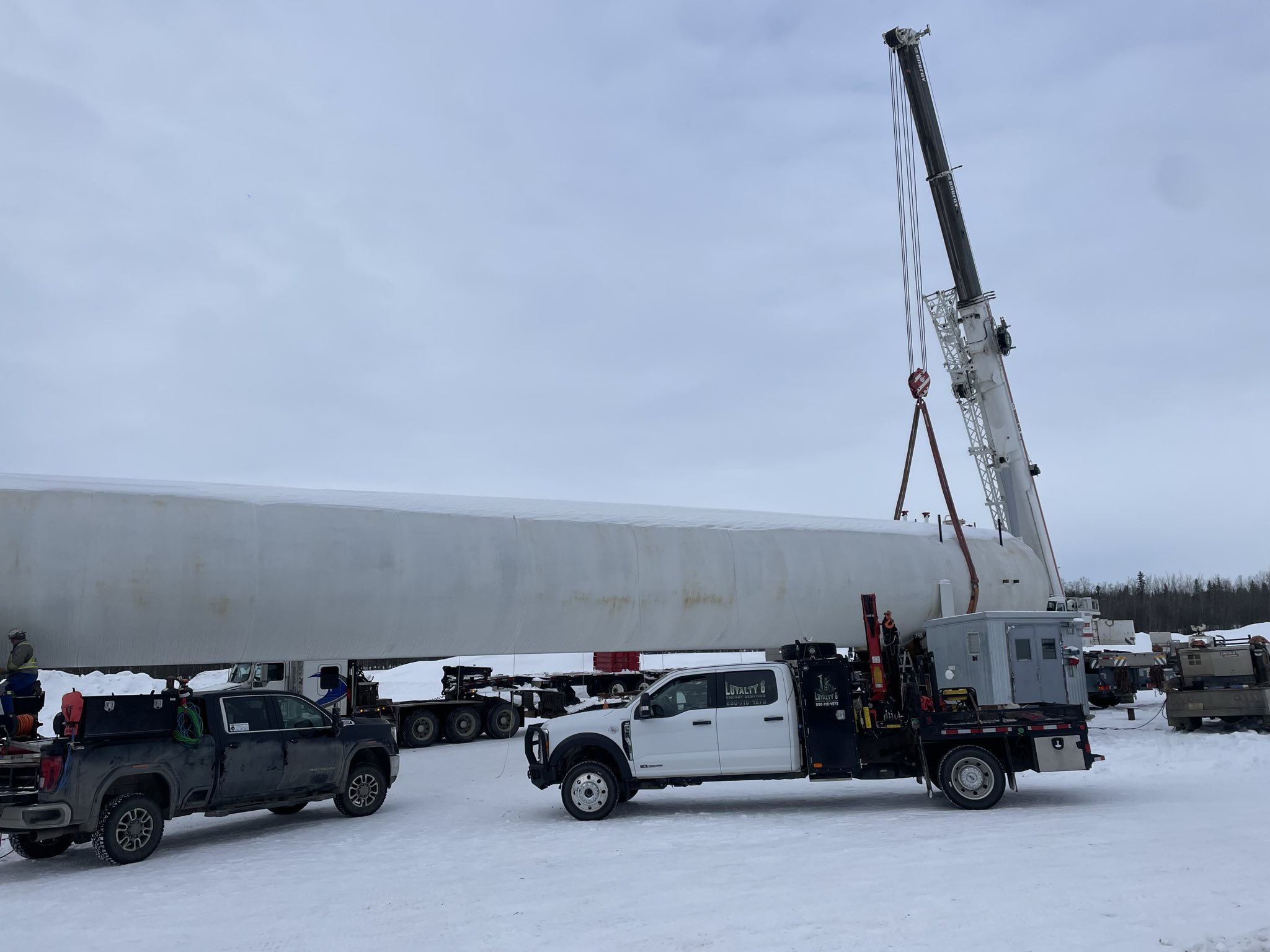Crew lifting large vessel at wellsite